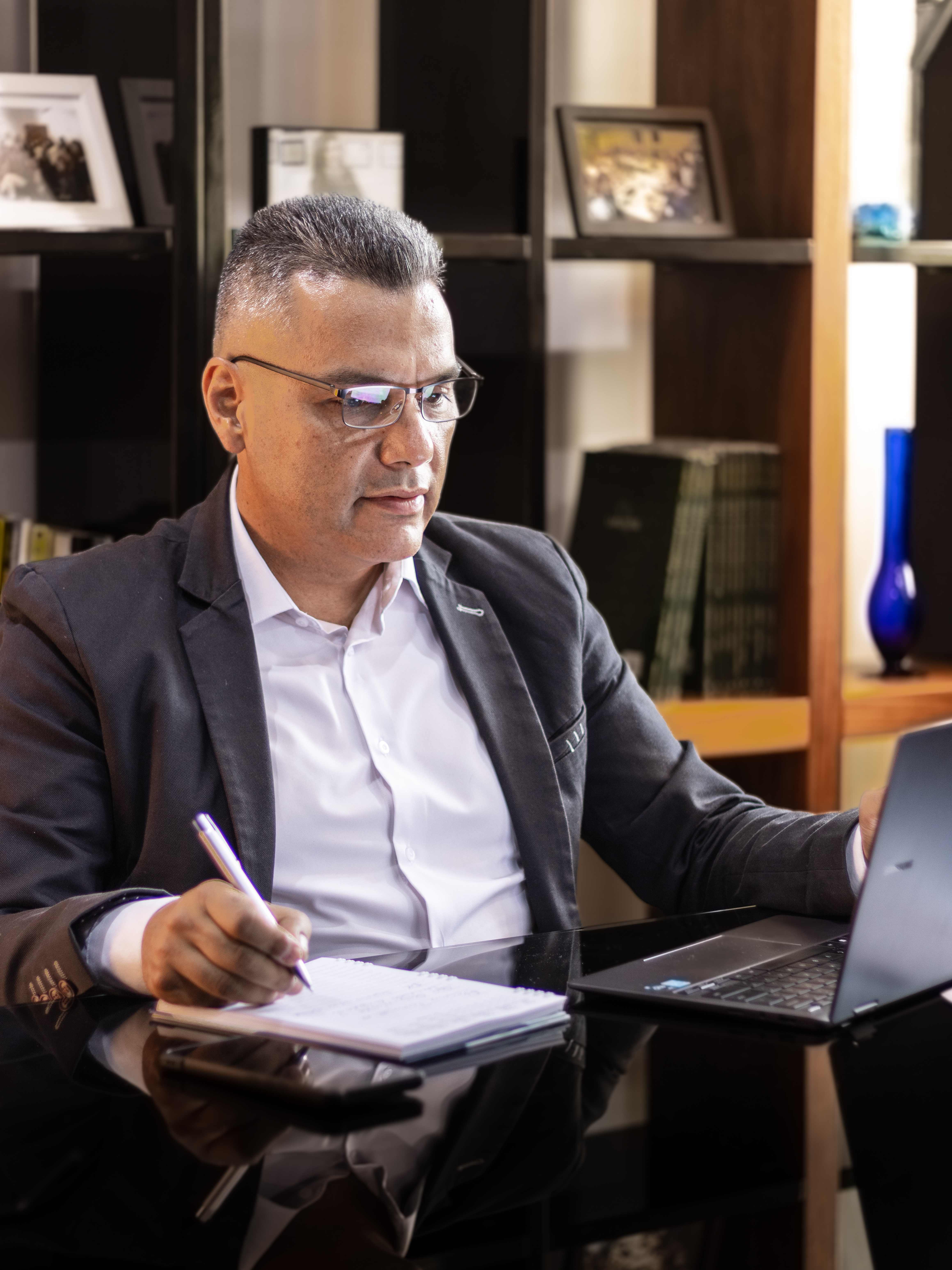 Miguel Quintero revisando laptop con lentes